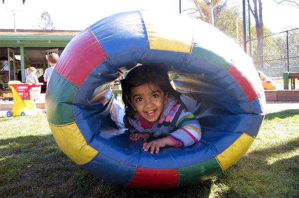 Girl smiling in play barrel