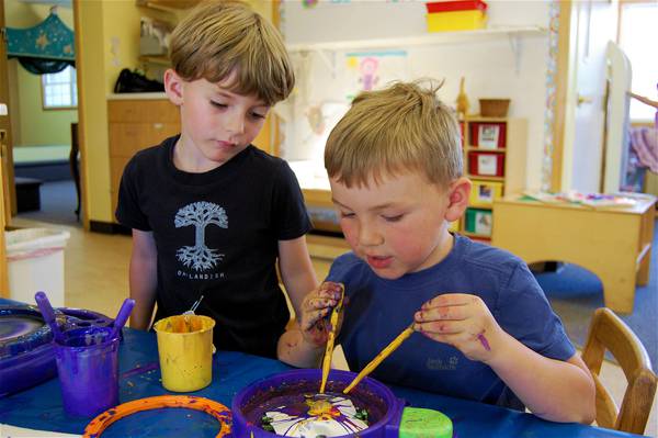 Two boys working at the art table